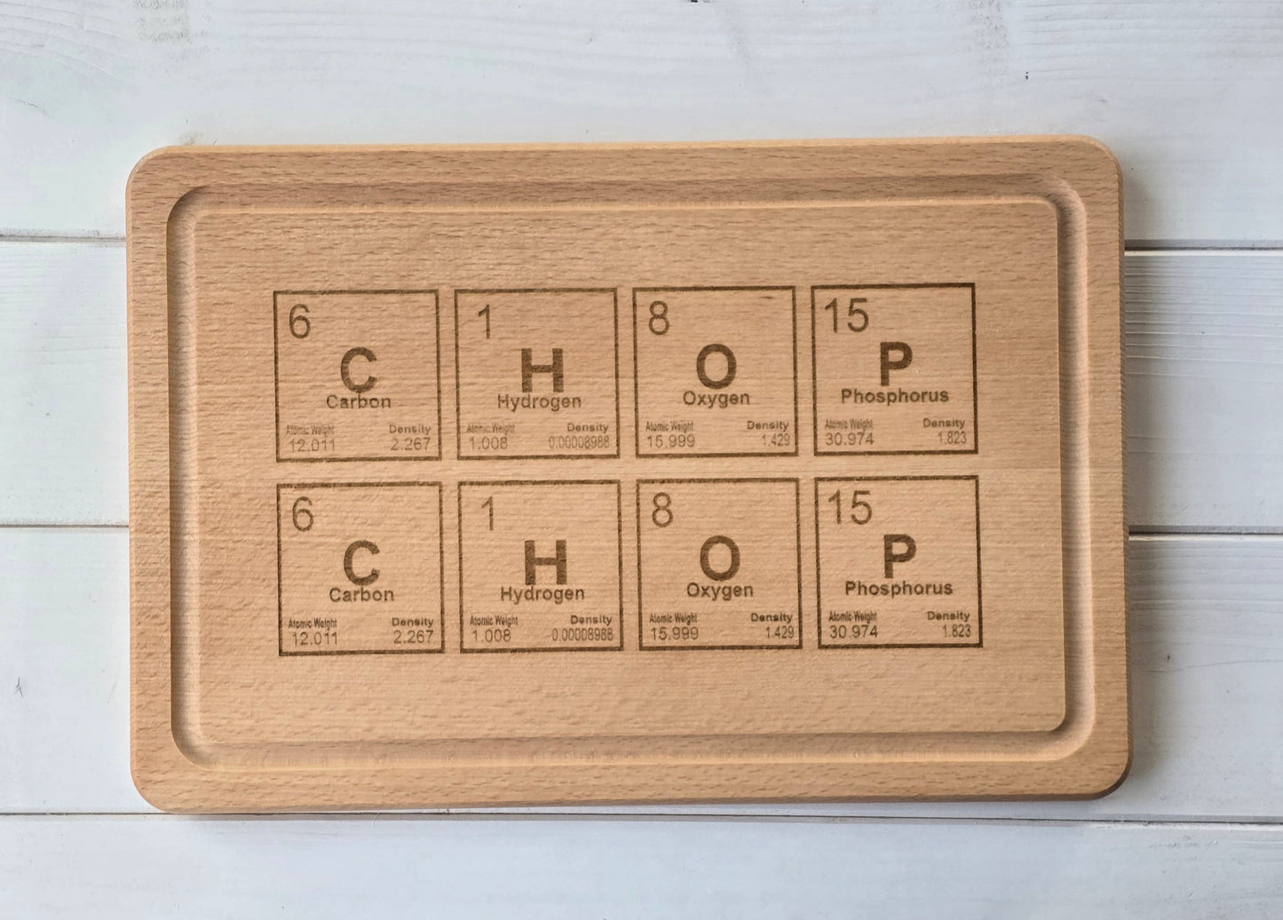 Wooden cutting board with engraved chemical formula on a light wooden surface
